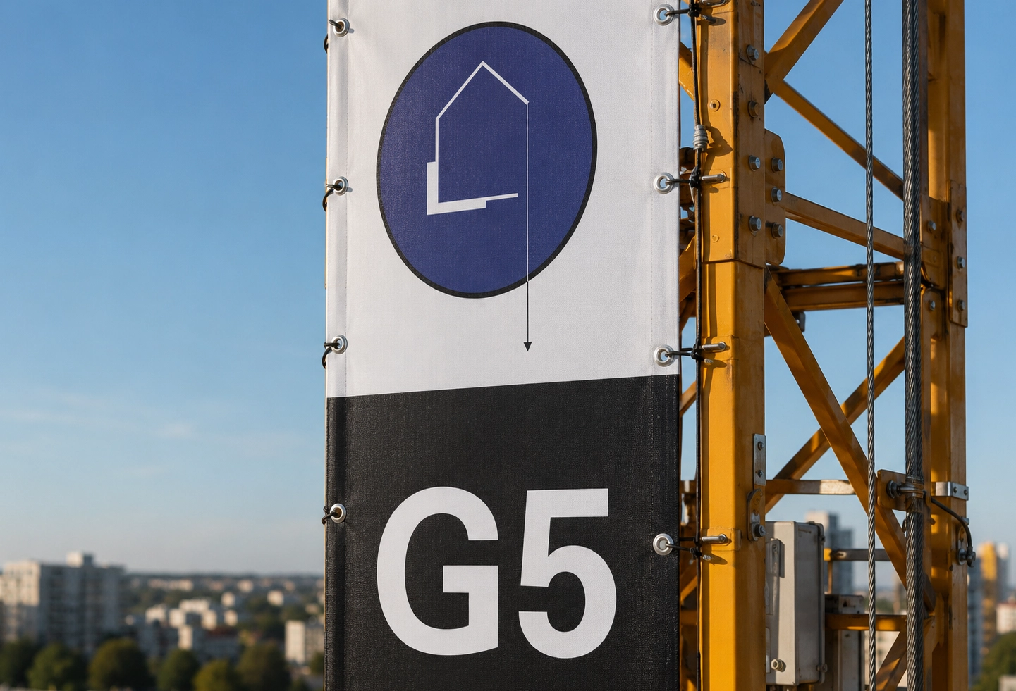 Détail des fixations et de la matière mesh d’une banderole grand format sur grue.