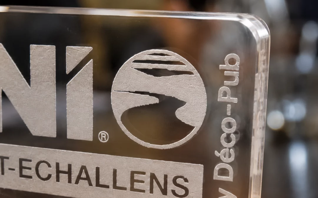 Détail d’une gravure laser blanche sur plaque en plexiglas transparent BNI Talent-Échallens.