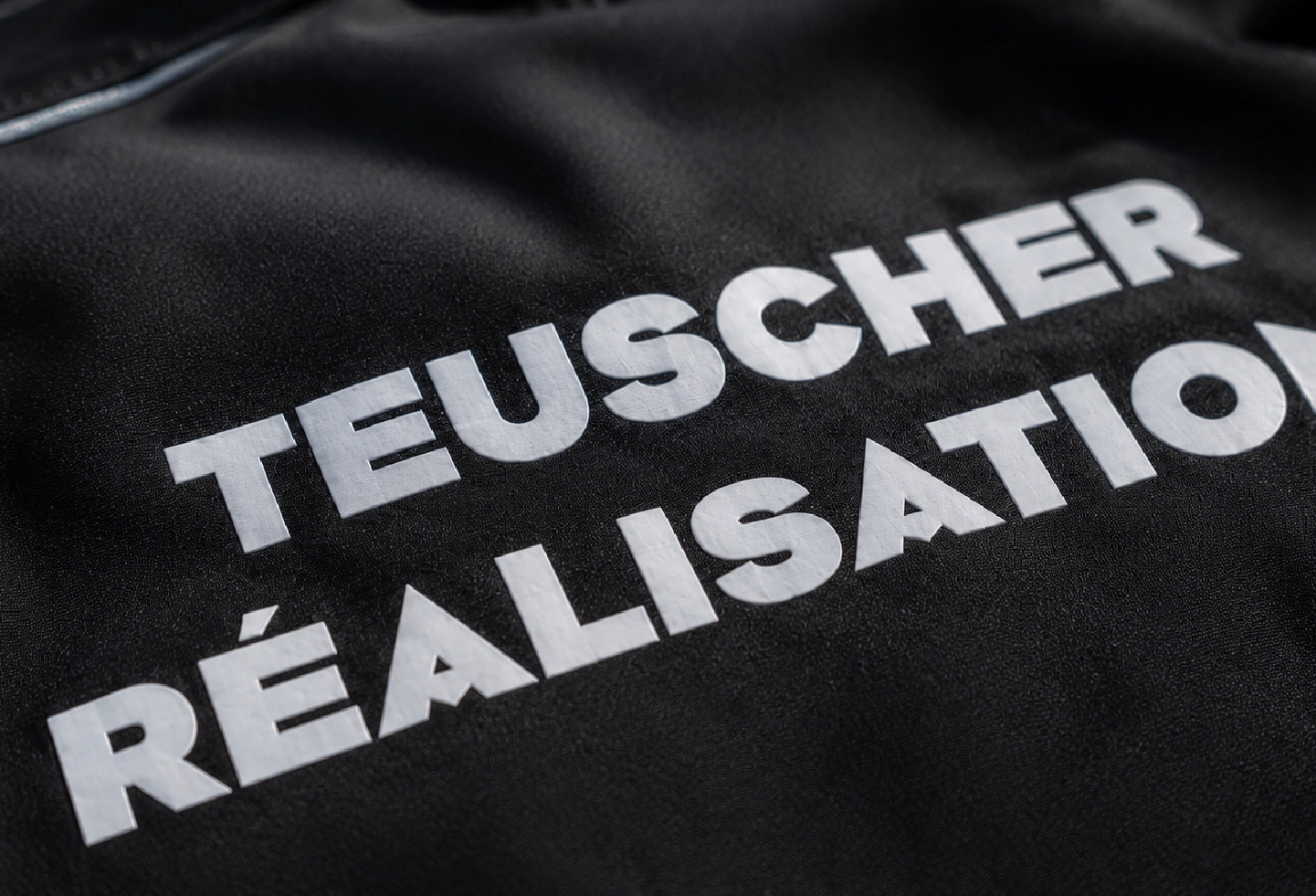 Gros plan sur un marquage DTF blanc appliqué sur une veste personnalisée avec une finition nette et durable.