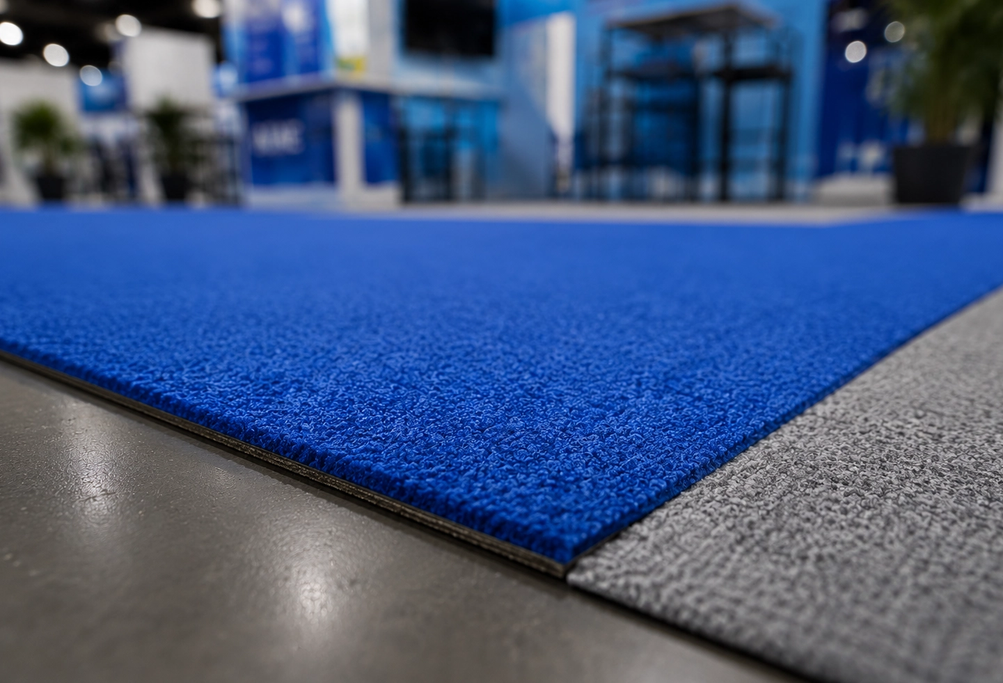 Gros plan sur les finitions d’une moquette événementielle professionnelle utilisée pour un stand d’exposition.