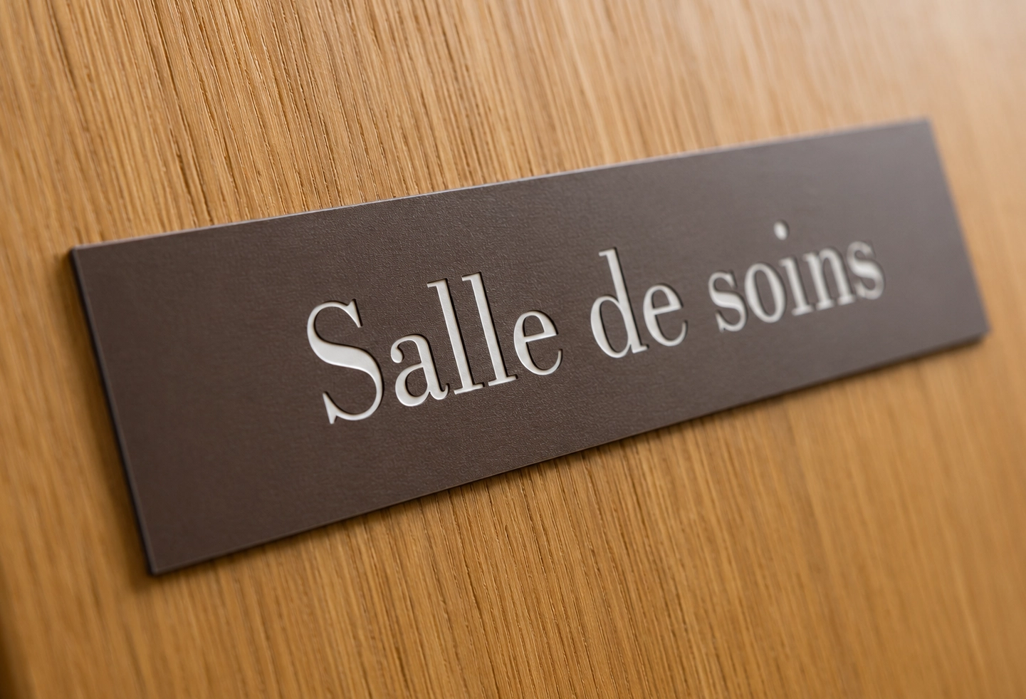 Gros plan sur une plaquette signalétique avec lettrage gravé et finition premium.