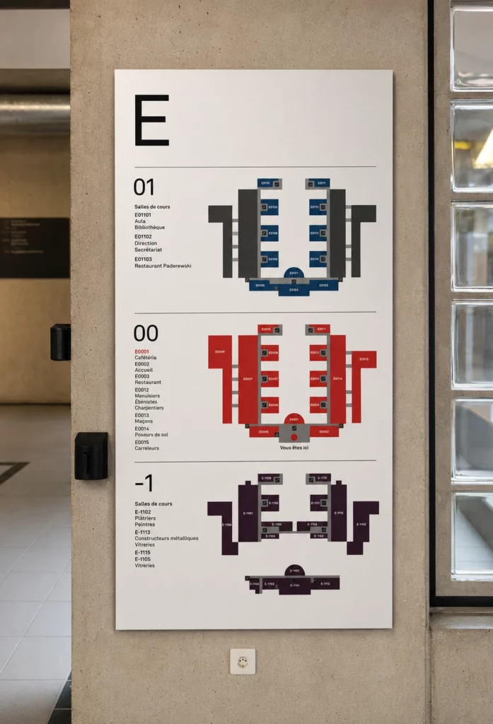 Panneau d'information avec plan d'orientation installé dans le hall d'un bâtiment professionnel.