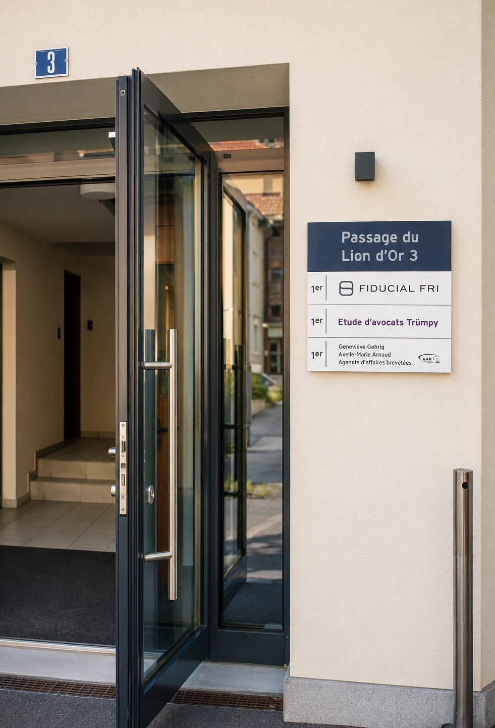 Plaque interchangeable installée à l’entrée d’un bâtiment professionnel avec plusieurs lignes de signalétique.