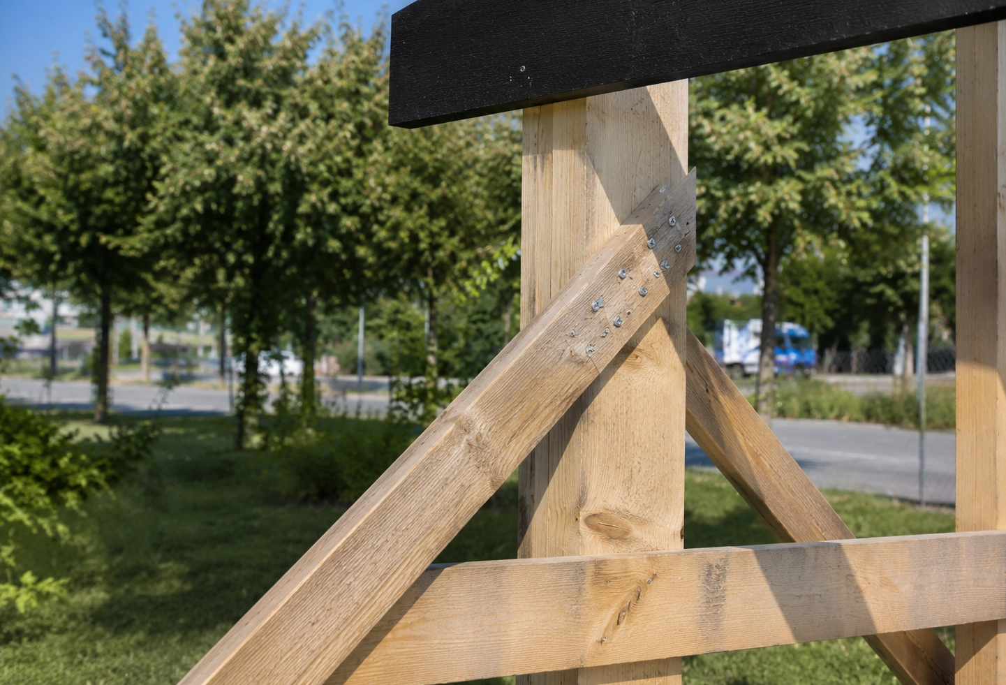 Détail des assemblages et renforts d'une structure en bois pour panneau de chantier.